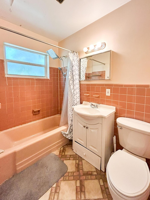 bathroom with vanity, a wainscoted wall, shower / tub combo, tile walls, and toilet