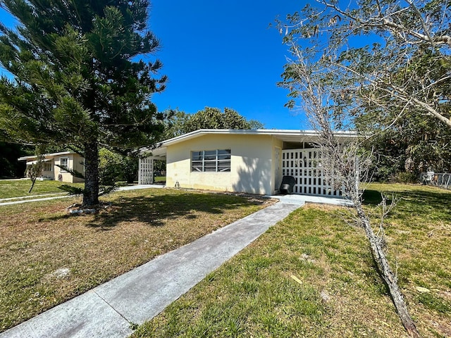 view of front of home with stucco siding and a front yard