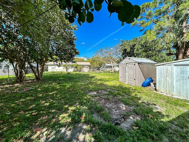 view of yard with a storage unit, an outdoor structure, and fence