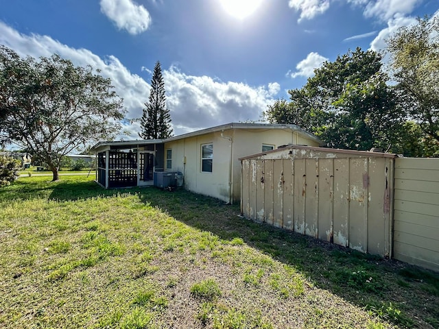 back of house with a yard, stucco siding, and fence