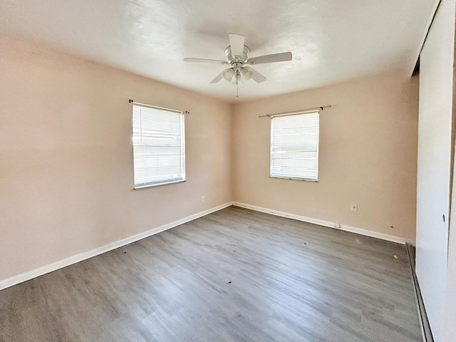 empty room with baseboards, a ceiling fan, and wood finished floors