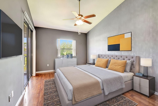 bedroom with vaulted ceiling, ceiling fan, baseboards, and wood finished floors