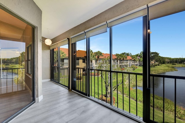 unfurnished sunroom featuring a water view