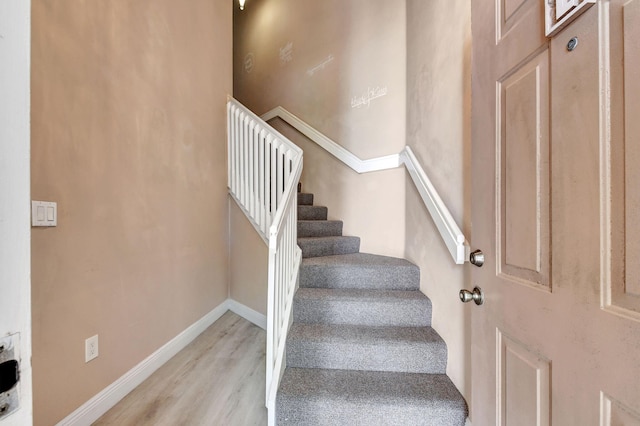 stairway featuring wood finished floors and baseboards