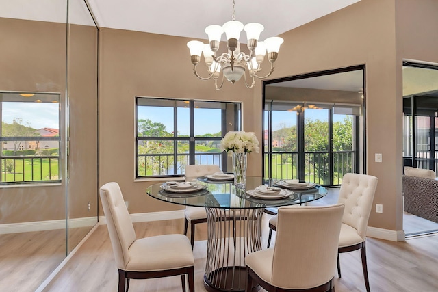 dining space featuring an inviting chandelier, light wood-style flooring, and baseboards