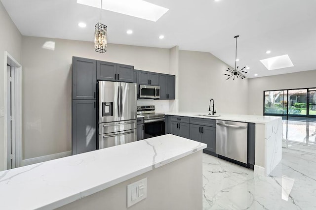 kitchen featuring light stone countertops, a peninsula, a sink, stainless steel appliances, and marble finish floor