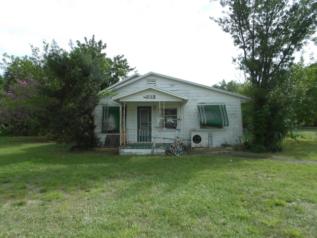 bungalow with ac unit, a porch, and a front lawn