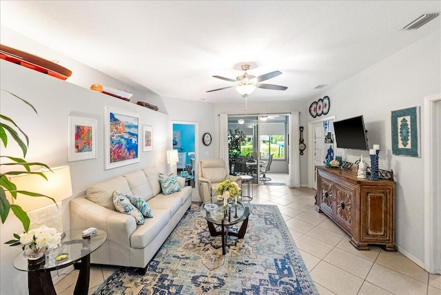 living room with light tile patterned flooring, baseboards, visible vents, and ceiling fan