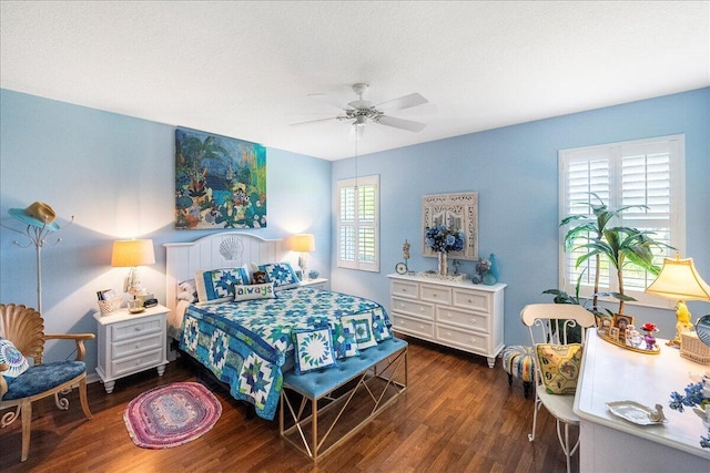 bedroom featuring a textured ceiling, a ceiling fan, and dark wood-style flooring