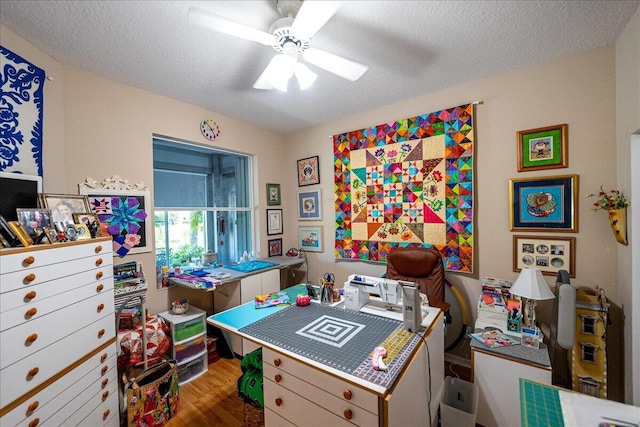 office space featuring a textured ceiling, ceiling fan, and wood finished floors