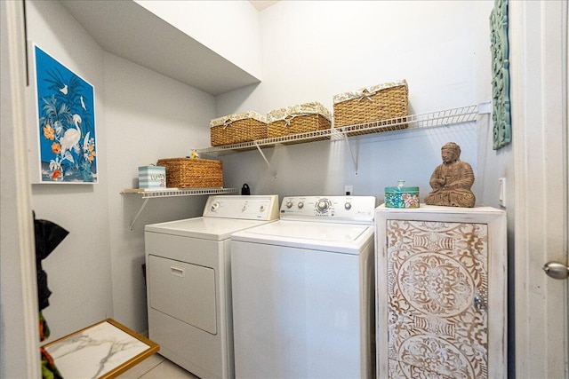 clothes washing area featuring separate washer and dryer and laundry area