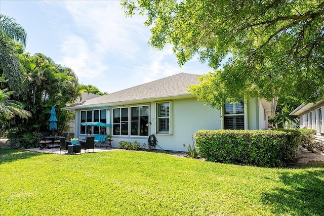 back of property featuring a lawn and a patio