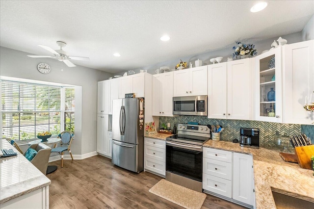 kitchen featuring glass insert cabinets, white cabinets, dark wood-style floors, and appliances with stainless steel finishes