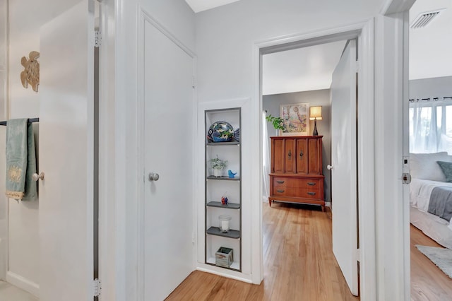 hallway with light wood-type flooring and visible vents