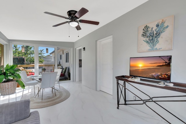 living room featuring marble finish floor and ceiling fan