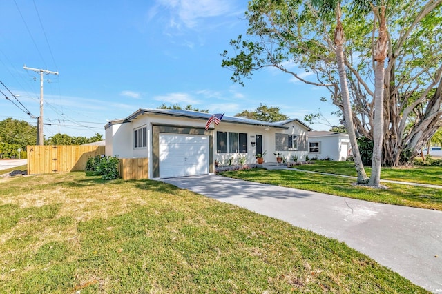 ranch-style home with a garage, concrete driveway, a front yard, and fence