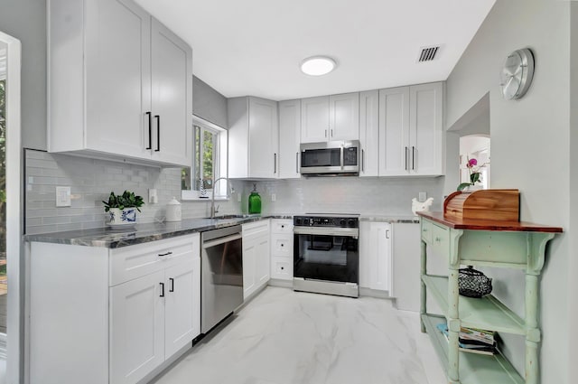 kitchen with visible vents, a sink, stainless steel appliances, marble finish floor, and tasteful backsplash