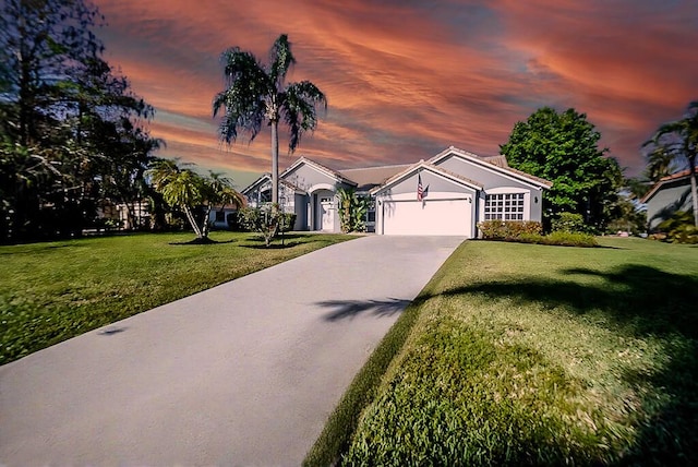 view of front of home featuring a front yard, an attached garage, and driveway