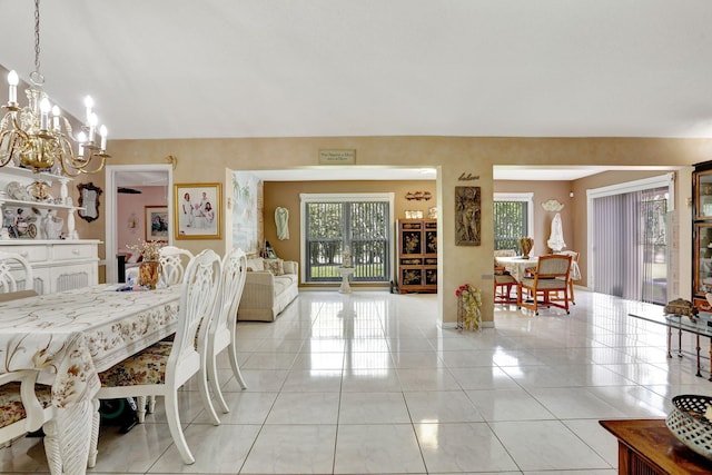 dining room with light tile patterned floors and an inviting chandelier