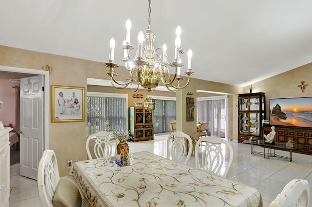 dining space featuring lofted ceiling, a chandelier, and tile patterned flooring