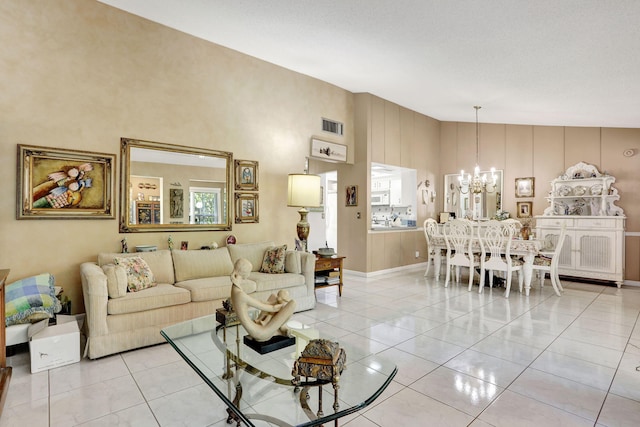 living area featuring light tile patterned flooring, visible vents, high vaulted ceiling, and an inviting chandelier