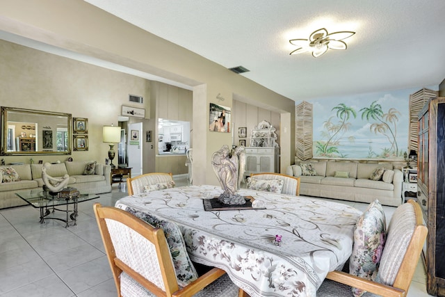 tiled dining area with visible vents and a textured ceiling