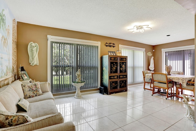 living area featuring light tile patterned floors and a textured ceiling