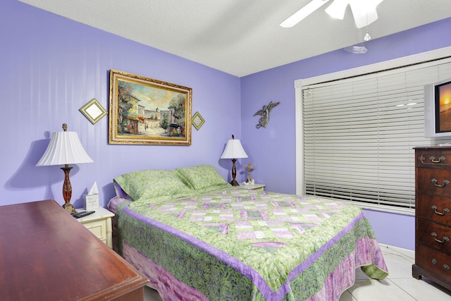 bedroom with light tile patterned floors, a ceiling fan, and a textured ceiling