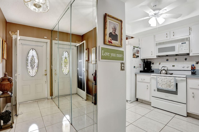 foyer entrance featuring light tile patterned floors and a ceiling fan