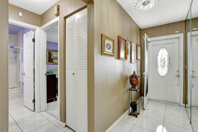 entryway featuring light tile patterned floors and a textured ceiling