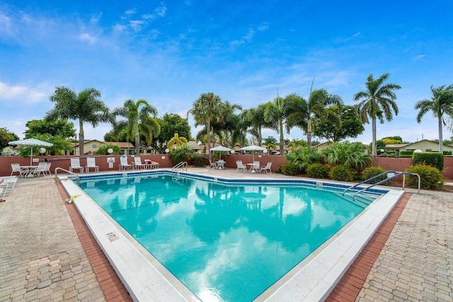 community pool featuring a patio area and fence