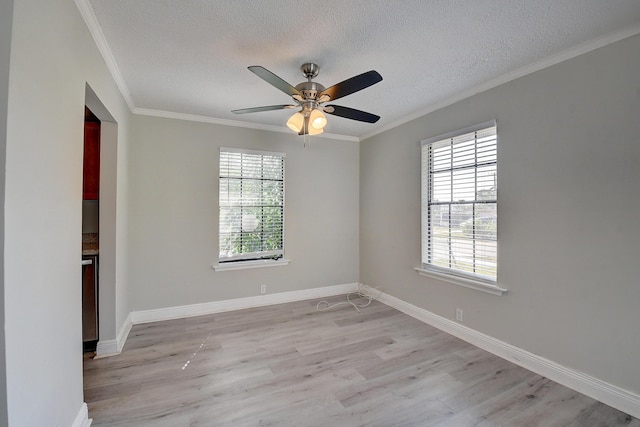 spare room featuring plenty of natural light, light wood-style floors, and ornamental molding