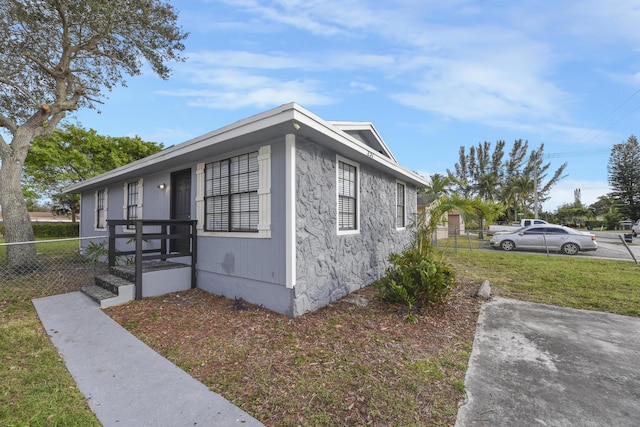 view of side of home with a yard and fence