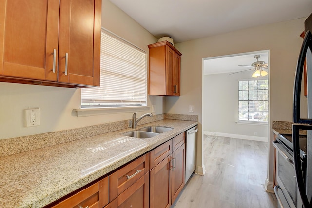 kitchen featuring light wood finished floors, a sink, stainless steel dishwasher, range, and brown cabinets