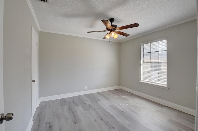 spare room with light wood-style flooring, ornamental molding, a textured ceiling, baseboards, and ceiling fan