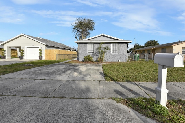 view of front of home featuring a front lawn, an attached garage, fence, and concrete driveway