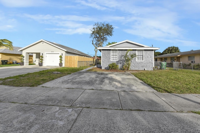 view of front of house with concrete driveway, an attached garage, fence, and a front lawn