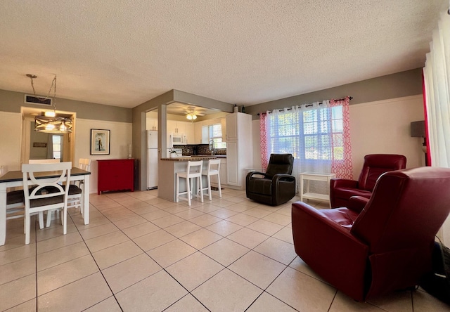 living room with light tile patterned flooring, visible vents, and a textured ceiling