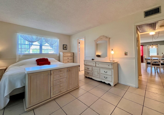 bedroom with multiple windows, light tile patterned floors, and visible vents