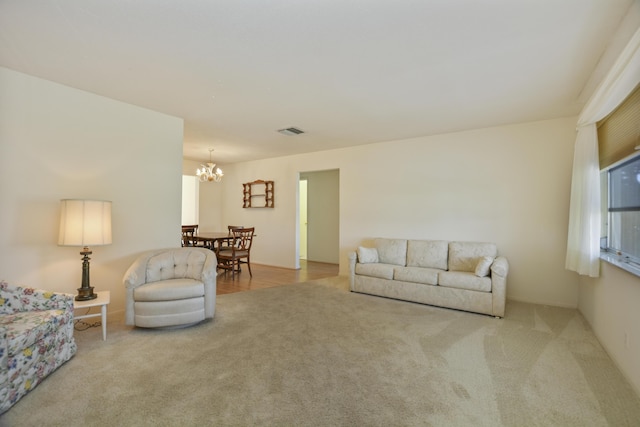 carpeted living area with visible vents and a chandelier