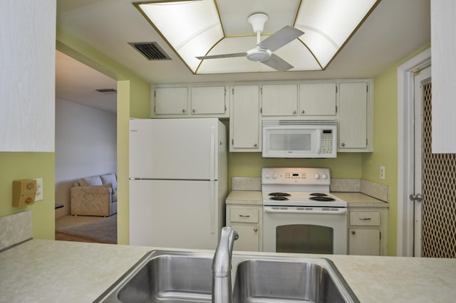 kitchen with white appliances, light countertops, visible vents, and a sink