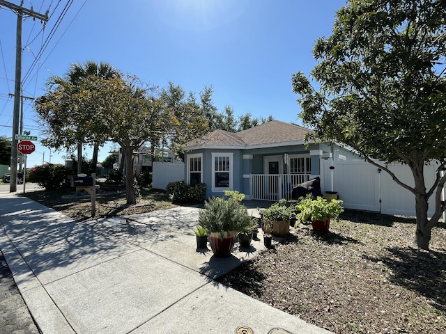 view of front of property with a shingled roof and fence