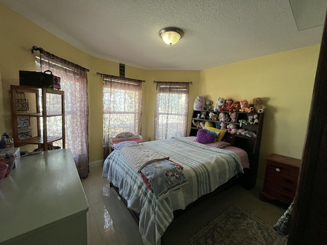 bedroom featuring tile patterned floors and a textured ceiling