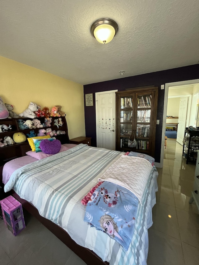 tiled bedroom featuring a closet and a textured ceiling