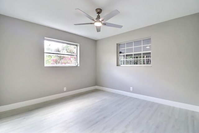 spare room with a ceiling fan, baseboards, and wood finished floors