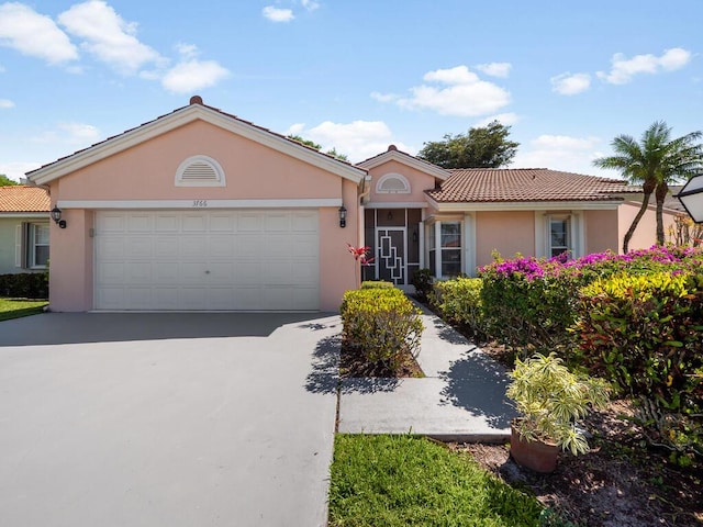 single story home with concrete driveway, an attached garage, a tile roof, and stucco siding