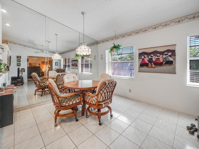 dining area featuring light tile patterned floors, baseboards, and a textured ceiling