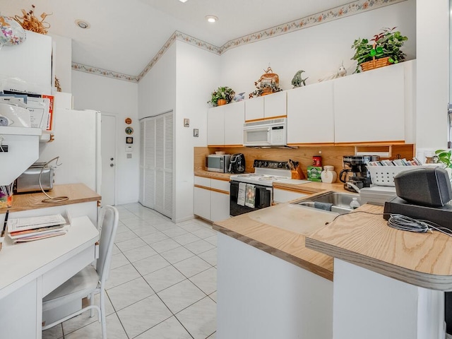 kitchen with range with electric cooktop, a high ceiling, light countertops, light tile patterned floors, and white microwave