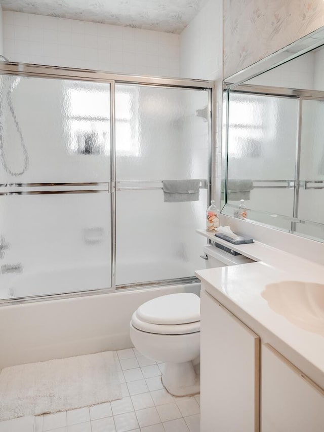 bathroom with plenty of natural light, shower / bath combination with glass door, vanity, and toilet