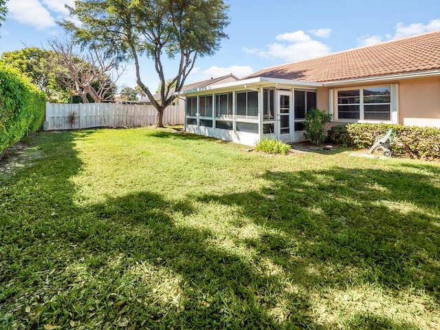 view of yard with a fenced backyard and a sunroom